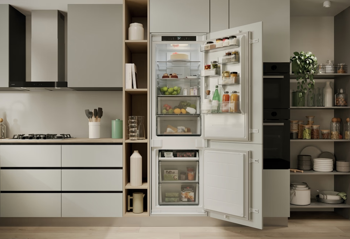 Απεικονίζεται το ψυγείο ανοιχτό εγκατεστημένο σε κουζίνα.